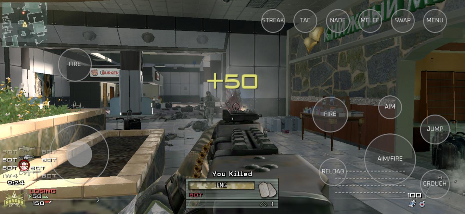 First-person view firing a belt-fed machine gun down an airport terminal concourse at bots, with a kill feed, scores and touch controls on screen